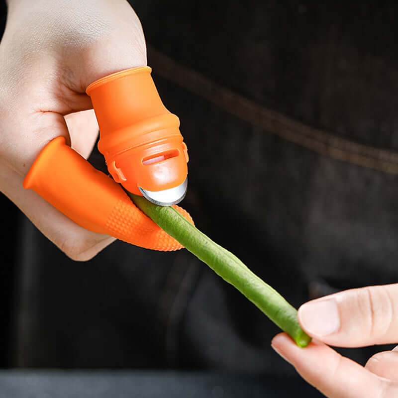 Silicone thumb knife protector protecting thumb while chopping vegetables